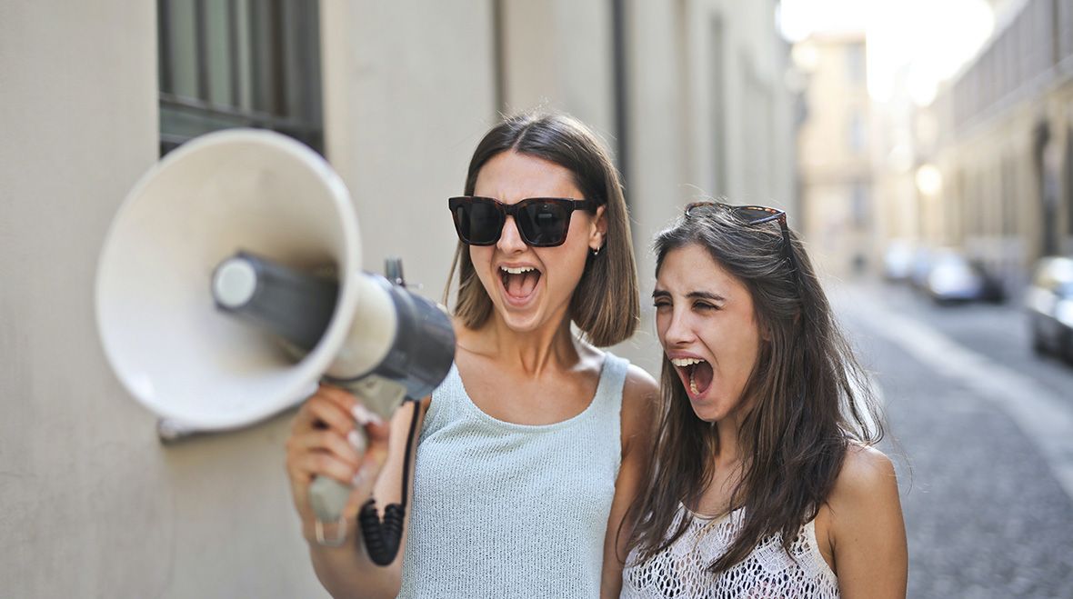 Two individuals shouting into a megaphone